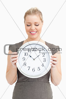 Woman looking at a clock in her hands
