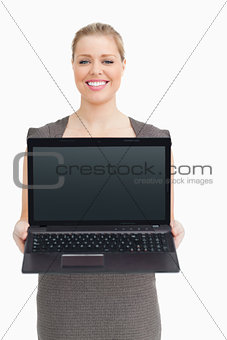Woman standing while showing a laptop