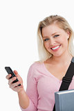 Smiling woman holding her cellphone and a novel