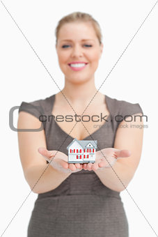 Woman showing a little model house