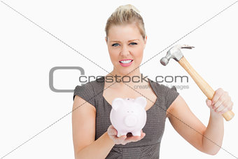 Woman want break a piggy bank with a hammer