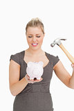 Serious woman with a piggy bank and a hammer