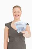 Woman smiling showing a euro banknotes fan