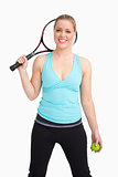 Woman smiling having a tennis ball and racquet