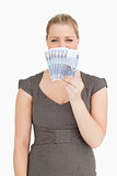 Pretty woman hiding her mouse with euro banknotes