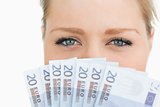 Close up of a woman face hidden with euro banknotes
