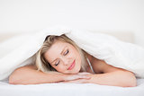 Young woman resting under her duvet