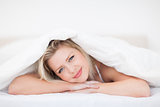 Young woman resting under a duvet