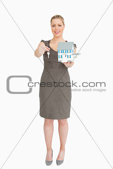 Businesswoman showing a model house and a key