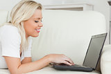 Woman lying while using a laptop