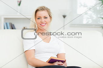 Woman sitting on a sofa with a book