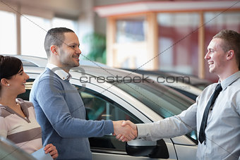 Smiling salesman shaking a customer hand