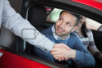 Man shaking the hand of a car dealer