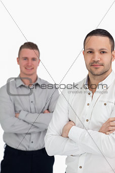 Two men crossing their arms as they stand up