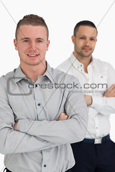 Two men smiling while crossing their arms