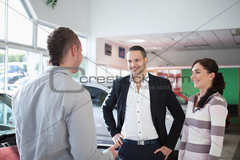 Car dealer chatting with a couple
