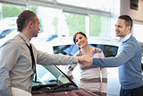 Car dealer shaking hand with a smiling man