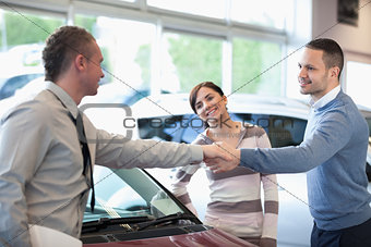 Car dealer shaking hand with a smiling man