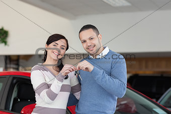 Smiling couple standing next to a car