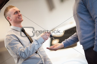 Smiling man giving keys to a man