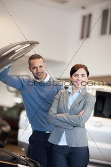 Happy couple in front of an open engine