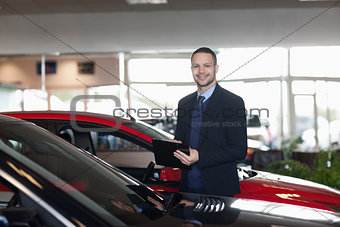 Man writing on a notepad beside a car