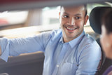 Man smiling while sitting in a car