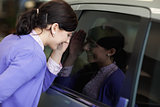 Woman looking inside a car
