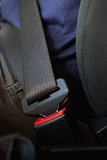 Person seated with fastened seatbelt