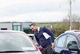 Man looking at a car while leaning 
