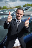 Businessman raising his thumbs while smiling