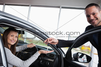 Woman sitting in her car while tending her hand
