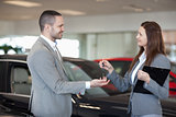 Woman giving car keys to a client