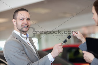 Man holding car keys with a businesswoman