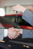 Close up of a woman giving car keys to a man