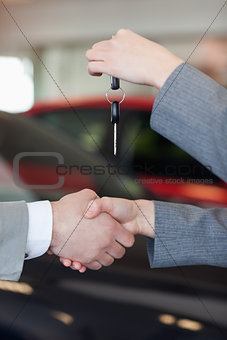 Close up of a woman giving car keys to a man