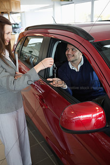 Businesswoman giving car keys to a customer