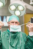 Surgeon putting on a surgical mask