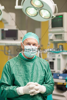 Surgeon smiling while crossing his hands