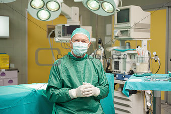 Surgeon smiling while joining his hands together