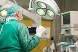 Surgeon wearing surgical equipment raising his arm