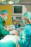 Patient lying on an operating table with two surgeons