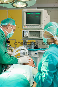 Patient lying on an operating table with two surgeons