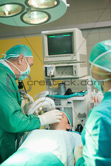 Surgeon putting an oxygen mask on a patient