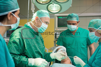 Smiling surgeon working with a team