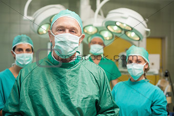 Smiling surgeon posing with a team
