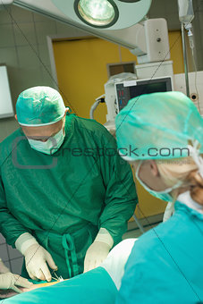 Surgeon holding scissors while operating