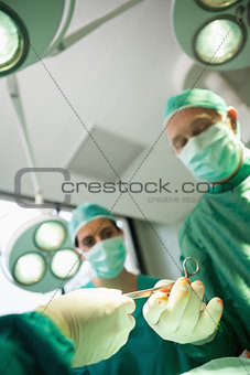 Close up of a scissors being given to a surgeon