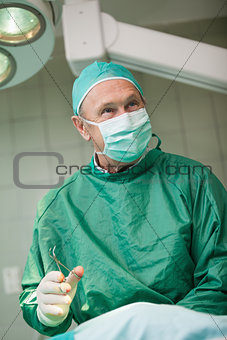 Smiling surgeon holding scissors