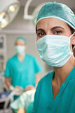 Smiling surgeon standing in front of a colleague
